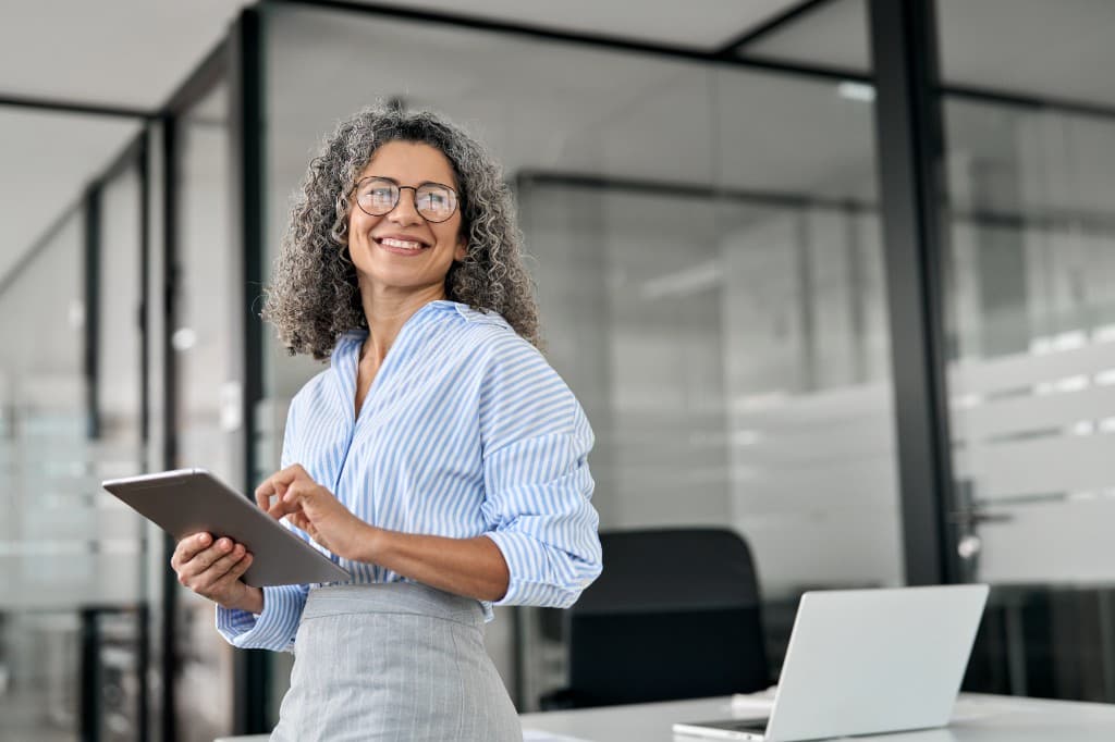 Illustrative photo of a business owner holding a tablet in an office
